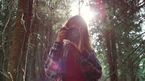 female photographer taking photos of forest landscape