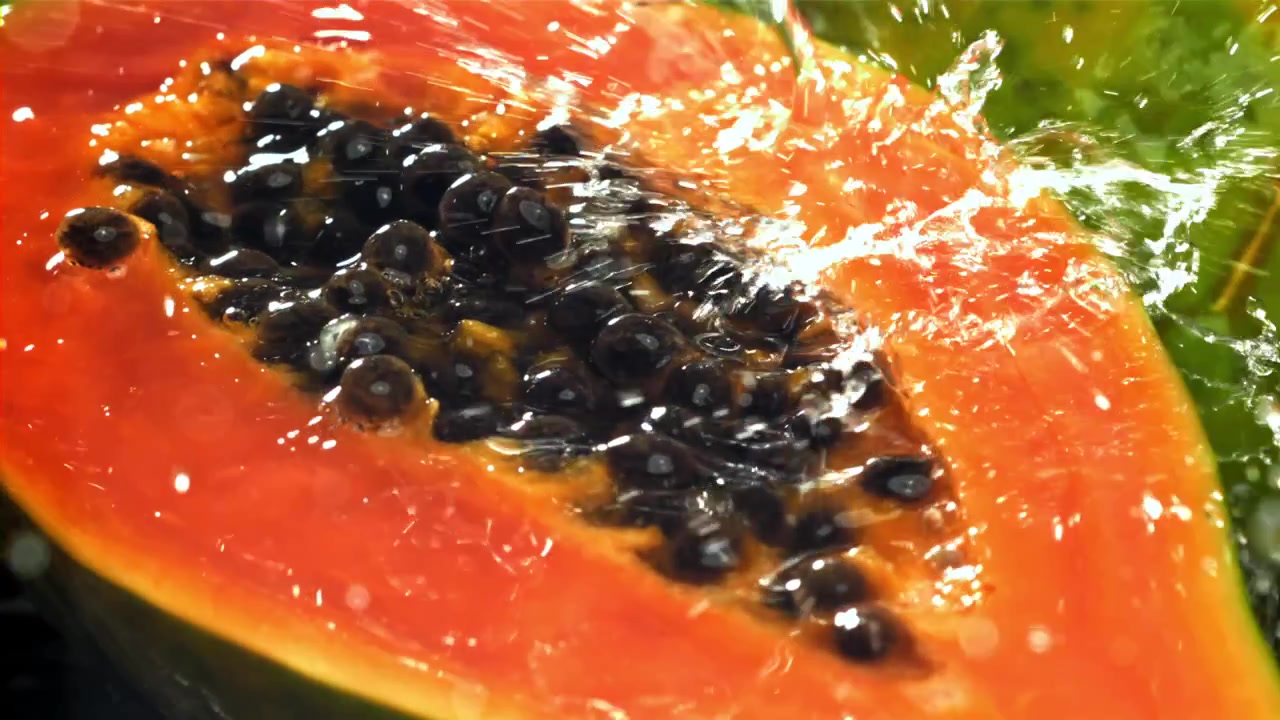 Friskende vann som spruter på en halvert papaya