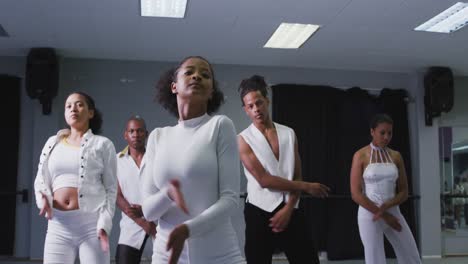 grupo multiétnico de bailarines modernos hombres y mujeres en forma practicando una rutina de baile
