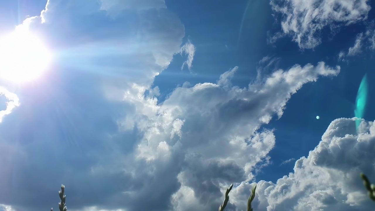 Il sole splendente splende attraverso le nuvole bianche soffice nel cielo blu
