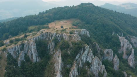 aerial view of mountain peak and cliffs on misty day