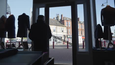 man leaving a traditional scottish tartan kilt store