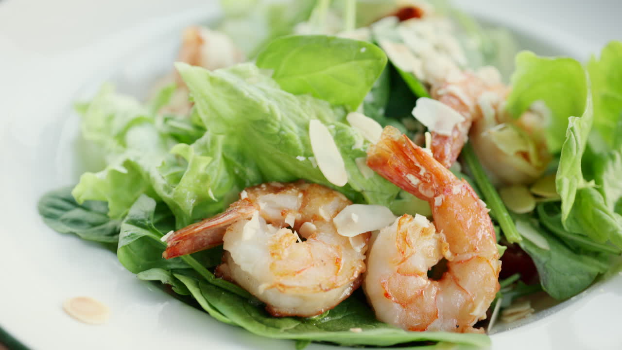 Close up of shrimp served on a fresh green salad with toppings