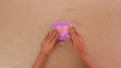 gluing paper heart on top of handmade valentine cardboard gift box