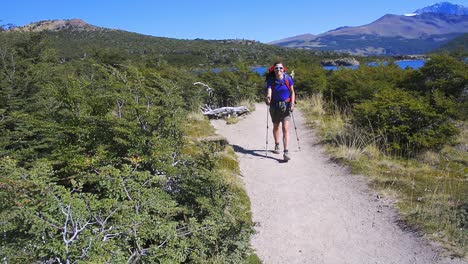 Junge-Frau,-Die-Auf-Einem-Weg-Geht-Und-Mit-Den-Händen-In-Patagonien,-Argentinien-Winkt