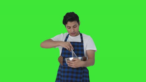 cocinero indio serio diciendo la receta mientras hace la comida pantalla verde
