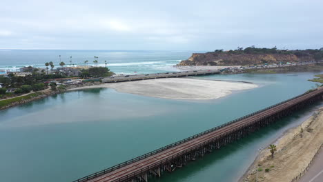 aerial flying over turquoise ocean water and lagoon in del mar, california