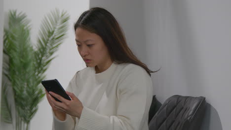 Stressed-Or-Anxious-Woman-At-Work-In-Office-Building-Reacting-To-Internet-Or-Social-Media-News-Message-Or-Story-On-Mobile-Phone-1