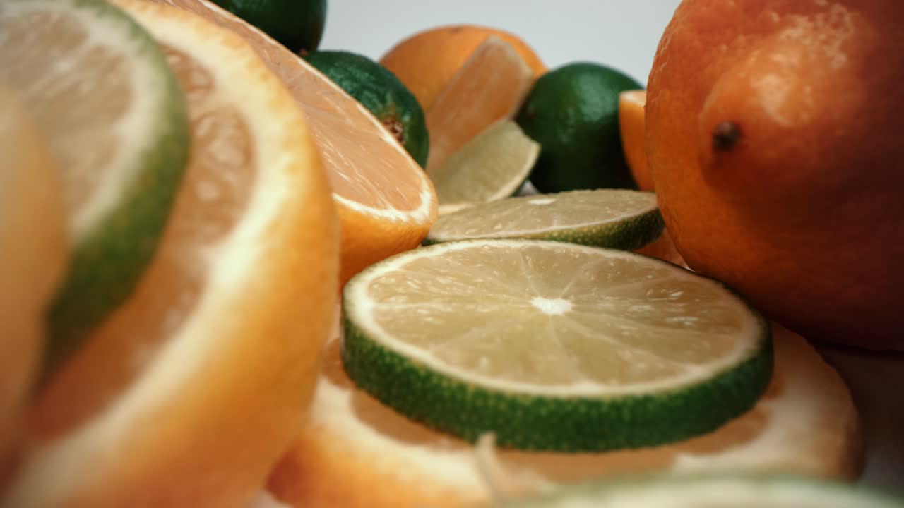 primer plano macro de torre de limón y lima con cuña de limón caída empuje en la sonda 4k video de comida de producto pila de cítricos frescos