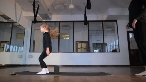 a young girl diligently practices various jumping techniques with professional guidance in a gym a young girl diligently practices various jumping techniques with professional guidance in a gym setting