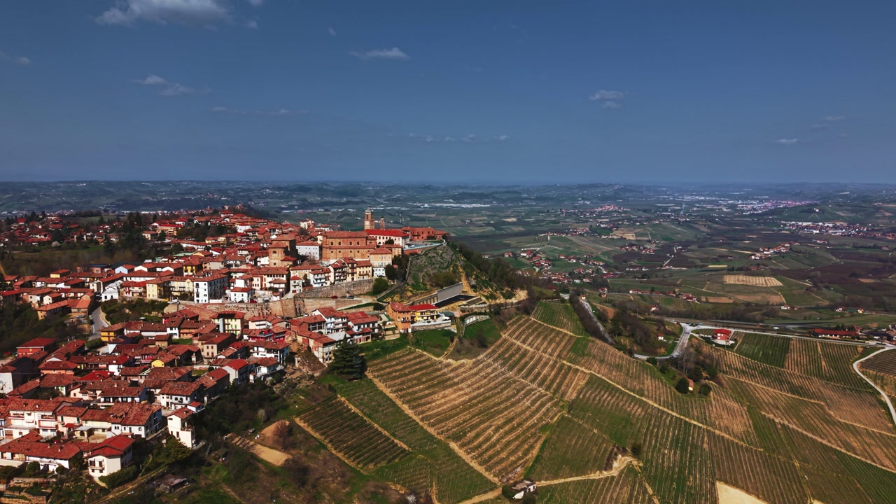 Stunning spring landscape of La Morra with Barolo vineyards and old town buildings, aerial drone view