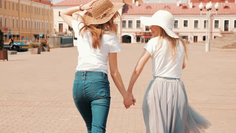 two happy young women walking in a city square