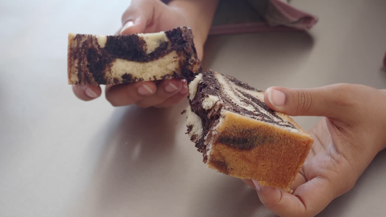 대리석 케이크 조각을 들고 있는 여자