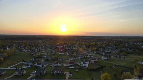 flying toward and past a water tower during a beautiful sunset, revealing a suburban neighborhood