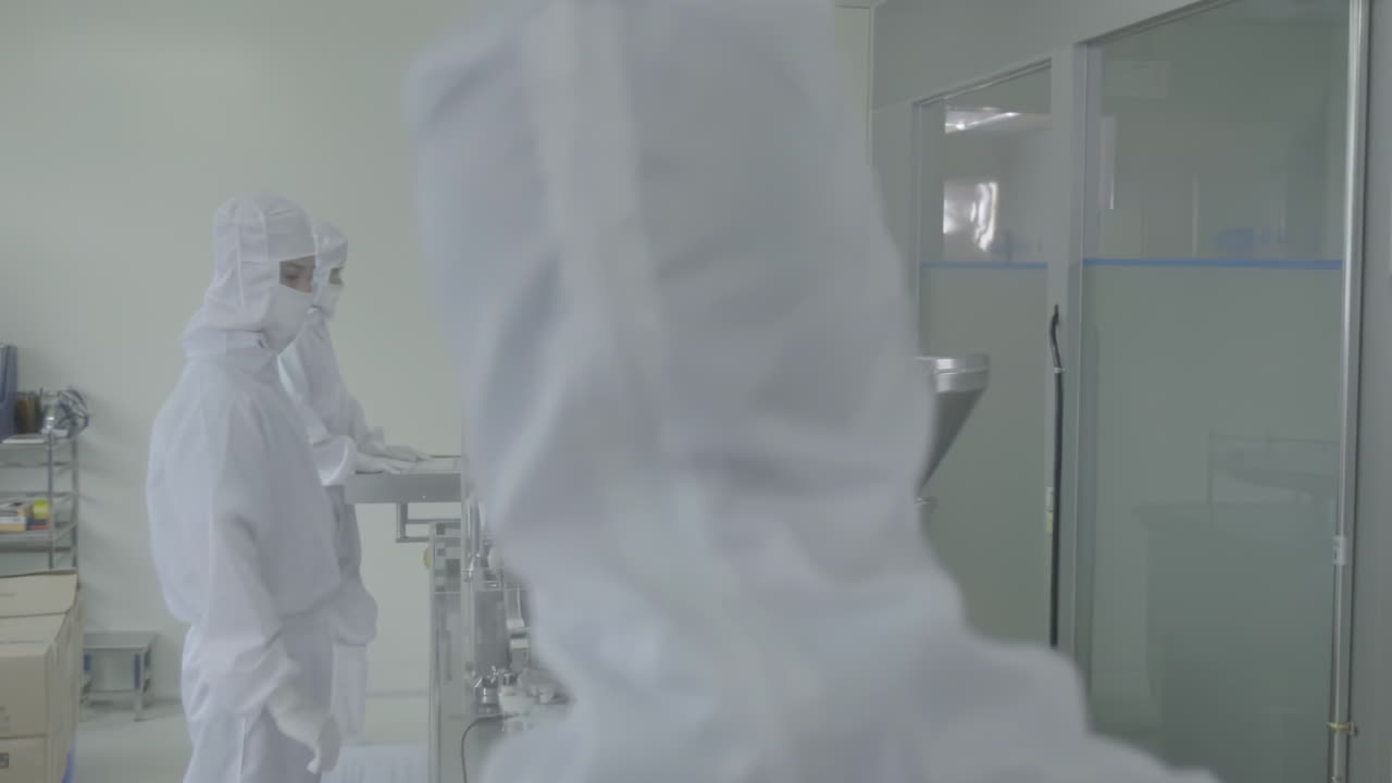 Technicians in protective clothing pharmaceutical production line in modern factory, laboratory worker filling vials with liquid, Scientist Testing Medical Vials on Conveyor Belt