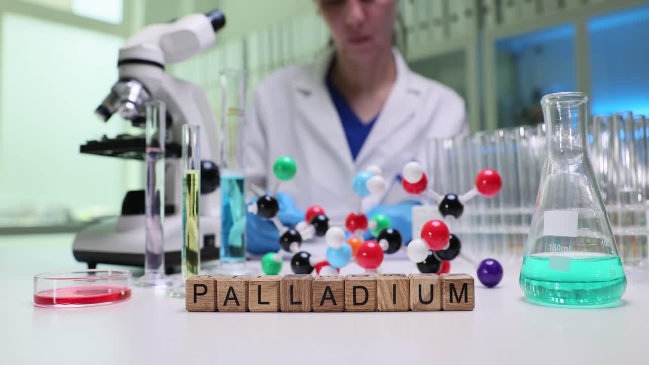 Scientist in a laboratory with palladium blocks and molecular models