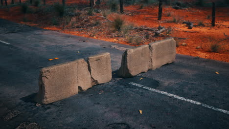 abandoned road in the australian outback with concrete roadblocks