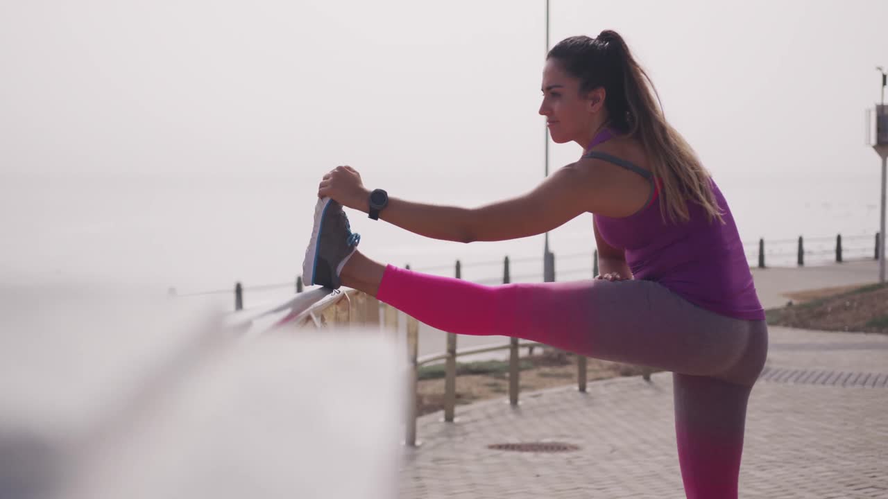 mujer caucásica estirándose contra una barrera