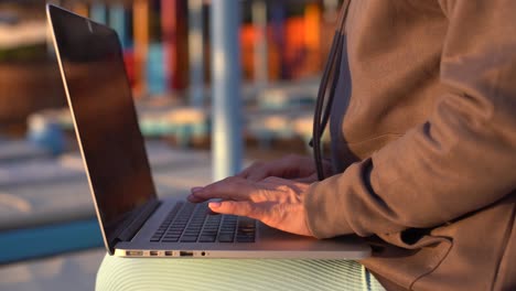 Manos-Femeninas-De-Una-Mujer-De-Negocios-Trabajadora-Usuaria-Profesional-Escribiendo-En-El-Teclado-De-Una-Computadora-Portátil-Trabajando-En-Línea-En-La-Playa