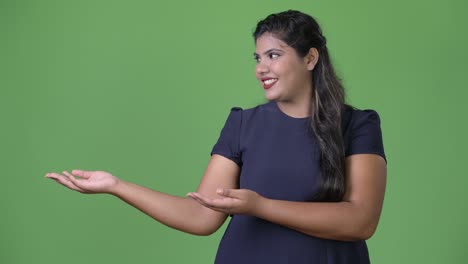 joven sobrepeso hermosa mujer de negocios india contra fondo verde