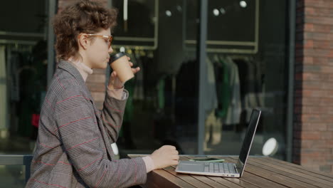 woman working on laptop in outdoor cafe