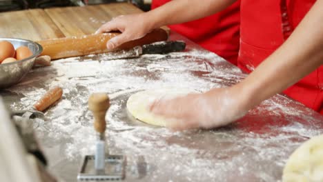 Male-and-female-baker-rolling-dough-in-bakery-shop-4k