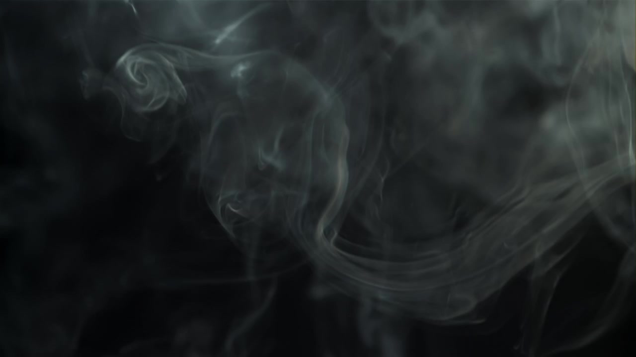 Fumo bianco etereo che si muove lentamente su sfondo nero.