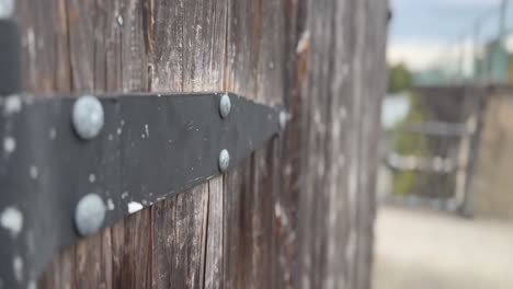 old hinge on a vintage wooden barn door - isolated close up