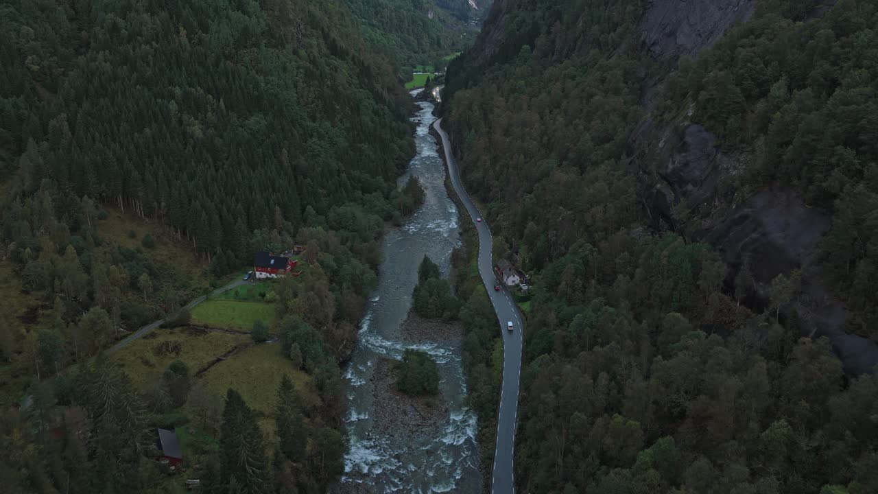 Una strada di valle norvegese si estende all'orizzonte all'alba.