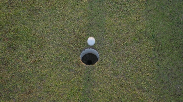 Colpo in rotazione di una pallina da golf imbucata al tramonto
