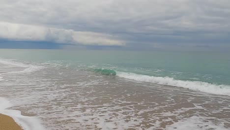 Grober-Sandstrand-Meereswelle-In-Zeitlupe-Bei-120fps-4k-Bewölkter-Tag-Türkisfarbenes-Wasser-Einzelne-Meereswellen-Großer-Leerer-Strand