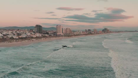 una larga playa en los ángeles durante la hora dorada desde la perspectiva de un avión no tripulado en el cielo