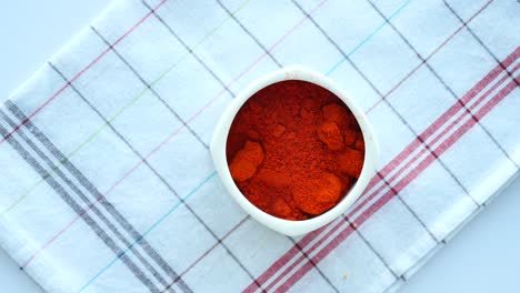 chili powder in a white bowl on a checkered tablecloth