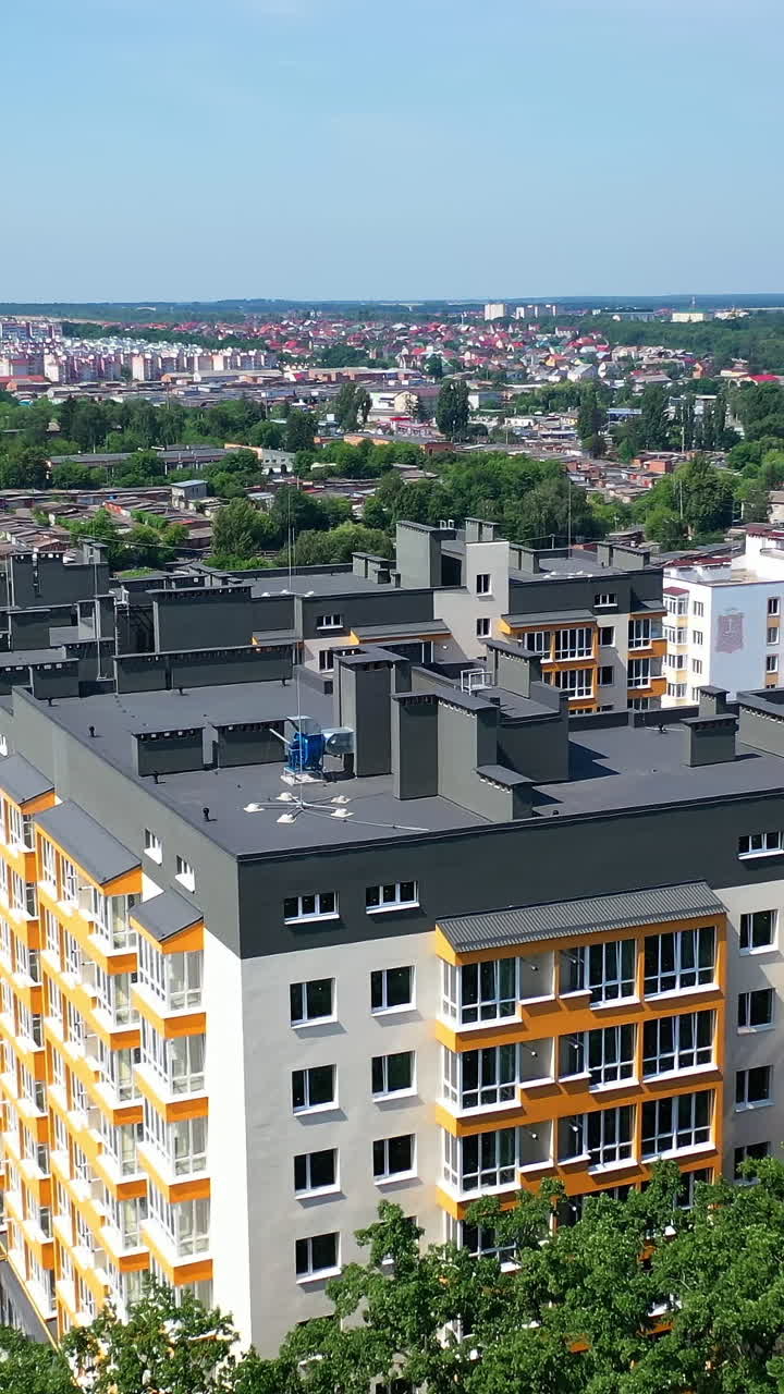 Modern residential building. View from the drone of the beautiful design of a new city complex. High-rise complex of apartment buildings with windows and balconies Vertical video