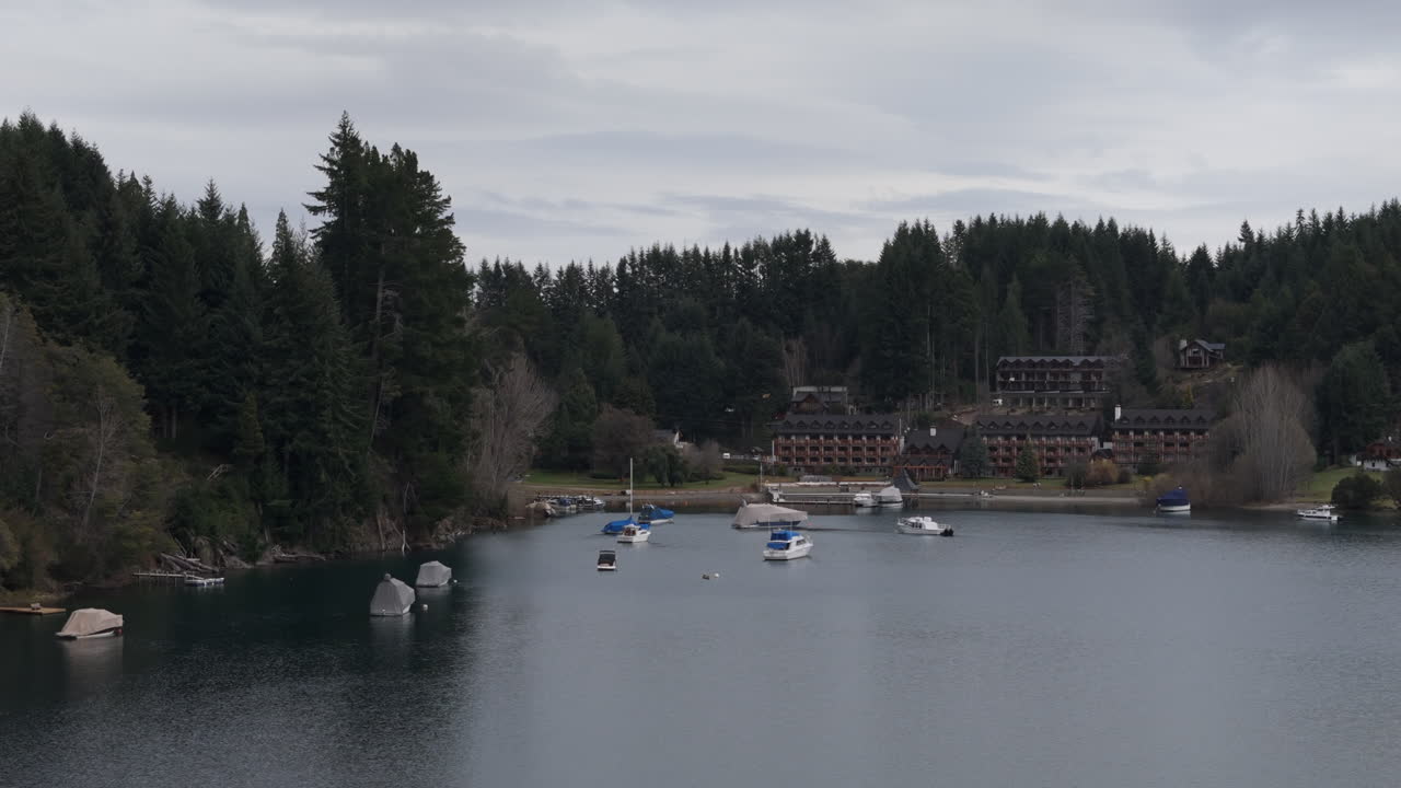 драматическое движение беспилотников вблизи курорта и гавани club andino с лодками, вилла-ла-ангостура, аргентина.