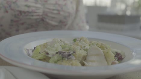 una mujer comiendo ensalada de césar.