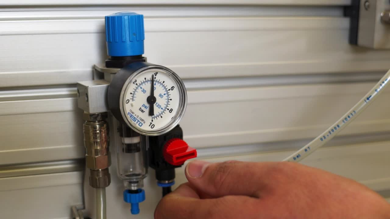 toma en cámara lenta de un ingeniero activando una válvula en un sistema hidráulico