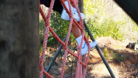 Determined-boy-climbing-a-net-during-obstacle-course