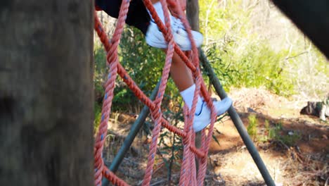 determined boy climbing a net during obstacle course