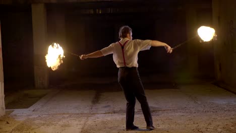 male artist performing fire show at dark in slow motion.