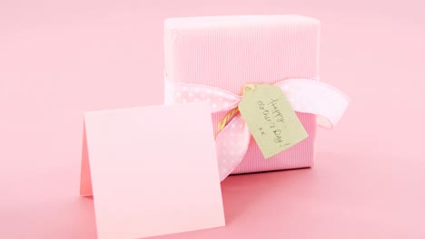 Gift-box-with-happy-mother-day-tag-and-blank-card-against-pink-background