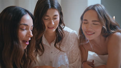 happy friends chilling home in evening closeup. joyful girls gossiping burning