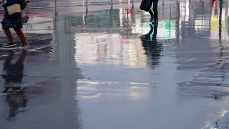 scene of people running on wet road during rush hour in the city of tokyo, japan