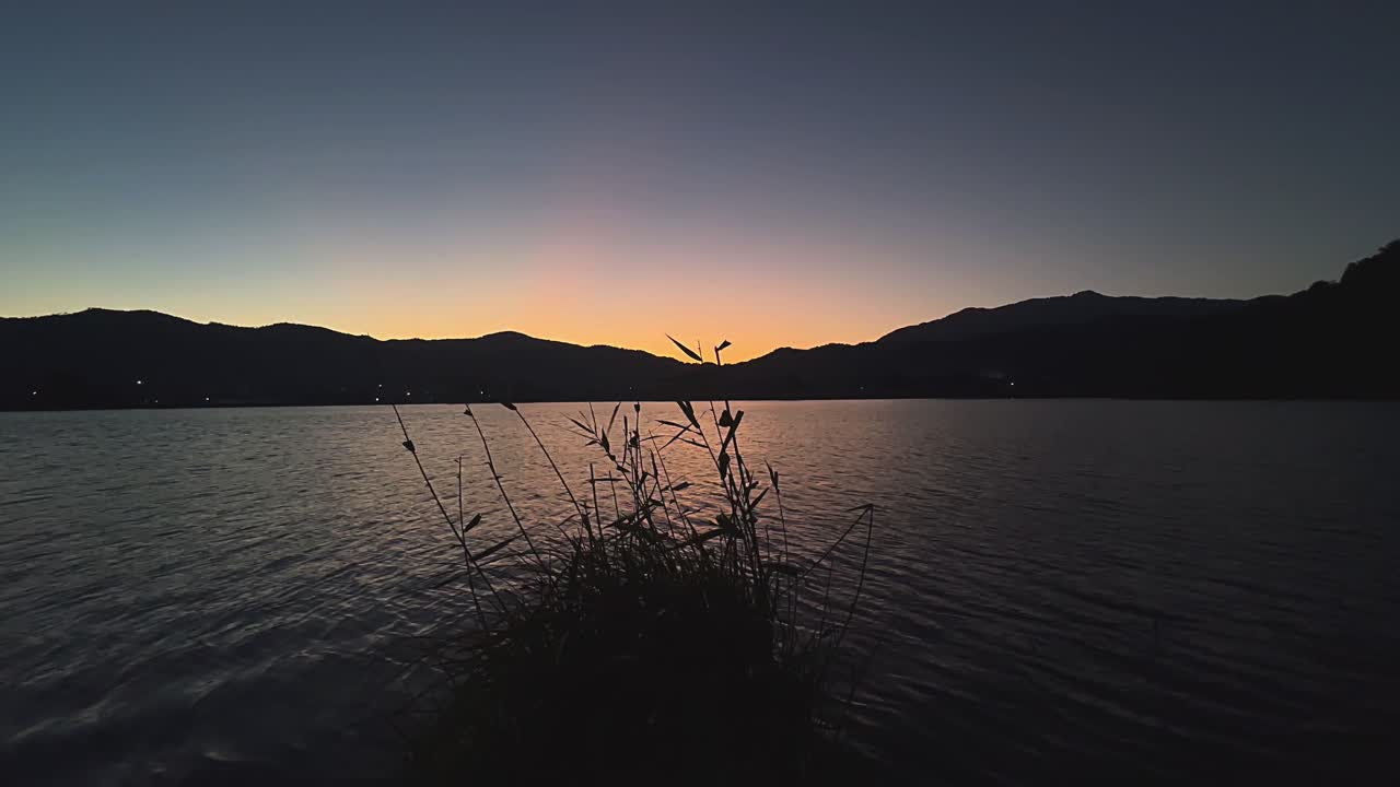 산 들 이 있는 호수 위 에서 해가 뜨거나 해가 지는 것