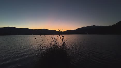 sunrise or sunset over a lake with mountains