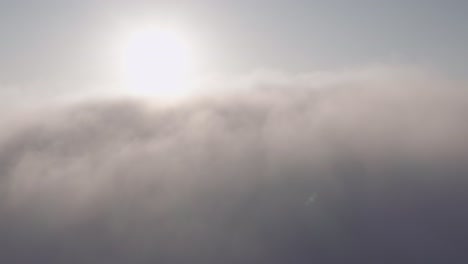 穿過雲端,從空中看到雲端上的太陽和山峰