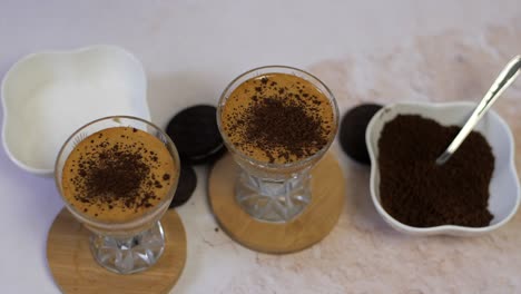 sprinkling chocolate crumbs on dalgona coffee, top view, slow motion