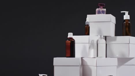 video of beauty products with white cardboard boxes with copy space over black background