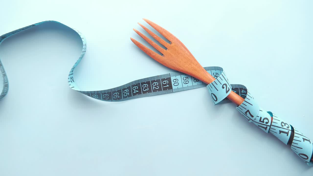 나무 포크는 측정 테이프에 감싸져 있습니다.