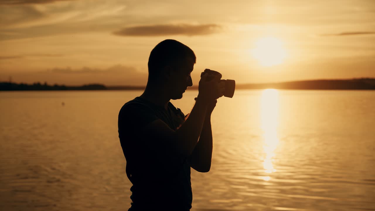 Photographer at the top of a hill by the river. Beautiful summer sunset